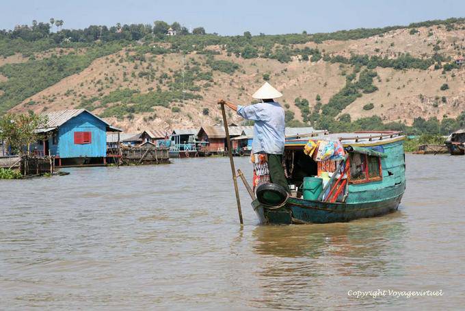 Galleggiante arriva in un villaggio su palafitte commerciante, Tonle Sap - Cambogia
