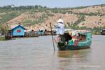 Galleggiante arriva in un villaggio su palafitte commerciante, Tonle Sap, Cambogia.