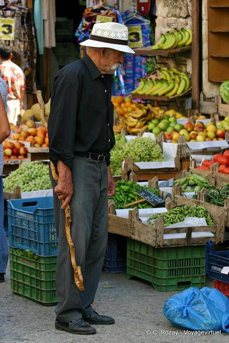 Canna cretese di fronte a una bancarella di frutta e verdura, Rethymnon - Creta, Grecia