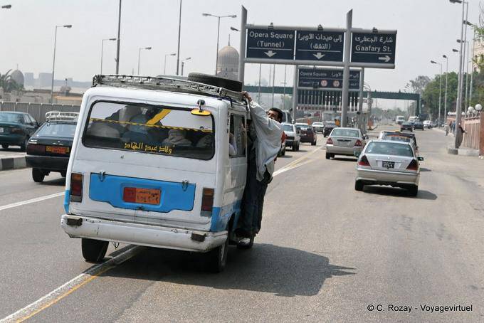 L'uomo appeso fuori il taxi sovraccarico, Cairo - Egitto