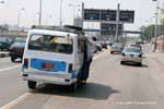 L'uomo appeso fuori il taxi sovraccarico, Cairo, Egitto.