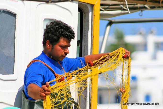 Milos, Pollonia, preparando reti da pesca sul porto - Grecia