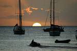 Deshaies, impostando metà sole tra le barche in silhouette, Guadalupa.