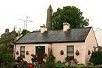 Rosa casa di fronte alla punta della torre rotonda, Killala Mayo, Irlanda.