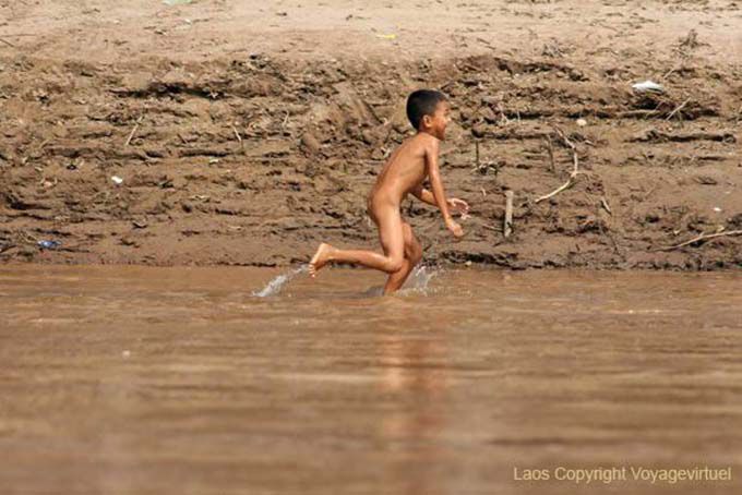 Giovane Lao esecuzione nuda sulla riva del Mekong Laos Sud, Laos