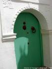 Una porta verde con una mano di Fatma, Asilah, Marocco.