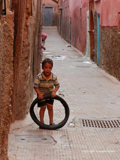 Un bambino che gioca con una pista pneumatico della Medina, Marrakech - Marocco