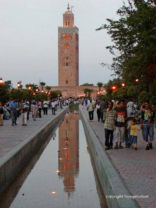 Riflessione del minareto illuminato in un laghetto nel giardino della Koutoubia, Marrakech - Marocco