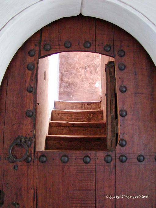 Apertura in una porta e scala in legno, Ben Youssef Madrasa, Marrakech - Marocco