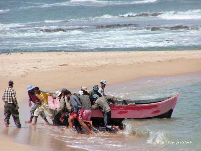 Sforzo combinato dei pescatori per portare la barca sulla sabbia, Oualidia - Marocco