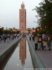 Riflessione del minareto illuminato in un laghetto nel giardino della Koutoubia, Marrakech, Marocco.
