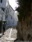 Ciottoli strada acciottolata e bambino che indossa i vestiti sulla sua testa, Chefchaouen, Marocco.
