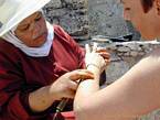 Un artista tatuaggio all'hennè officiante in prossimità dei bastioni, Essaouira, Marocco.