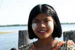 La ragazza in forma di foglio thanaka su U Bein Bridge, Mandalay, Birmania.