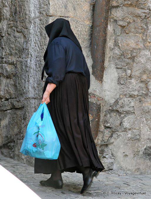 Orgosolo, una donna in costume tradizionale, vista posteriore - Sardegna