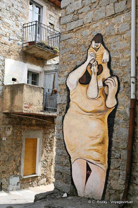 Orgosolo, la donna con il suo bambino sulle spalle, via d'Azeglio, a murale - Sardegna