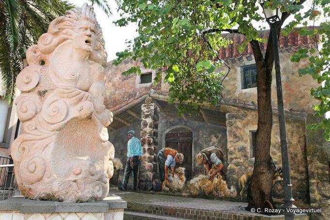 Tinnura, Piazza del Municipio, la statua monumentale e pittura di tosatura delle pecore - Sardegna