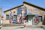 Orgosolo, Deus Bonu, murale sulla facciata di una casa, Sardegna.