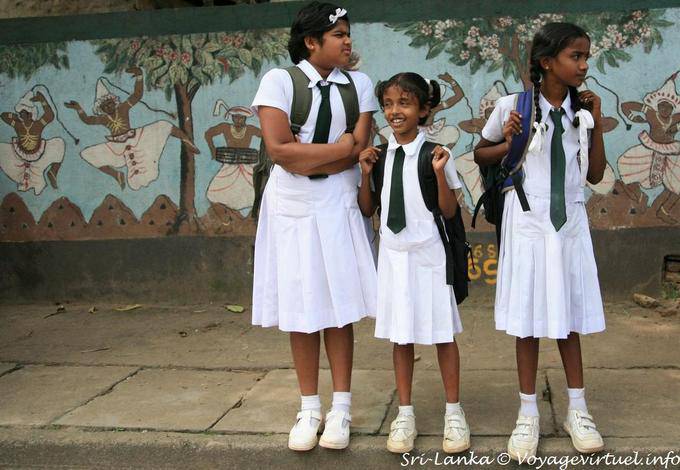 Trio di studentesse in uniforme davanti ad un murale, Kandy - Ceylon Sri Lanka