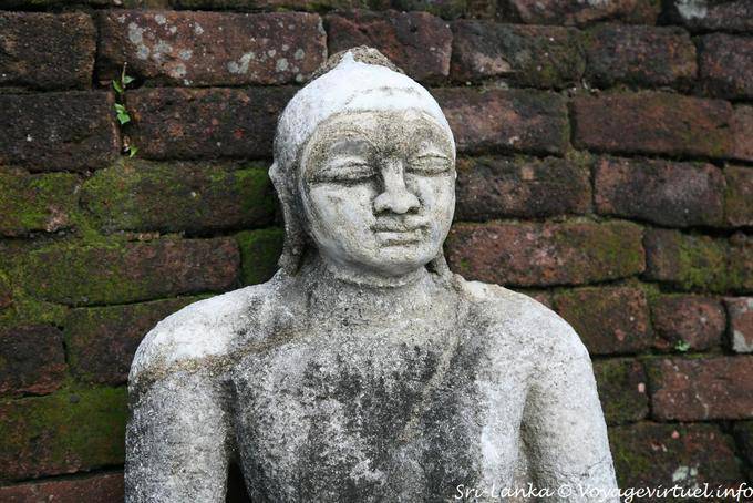 Granite busto di Buddha di fronte a un muro di mattoni, Medirigiriya - Ceylon Sri Lanka