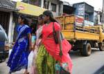 Tre giovani donne in sari corsa indietro, strada Matale, Ceylon Sri Lanka.