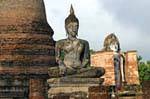 Buddha seduto di fronte al Phra Attharot, Sukhothai, Wat Mahathat, La Tailandia.