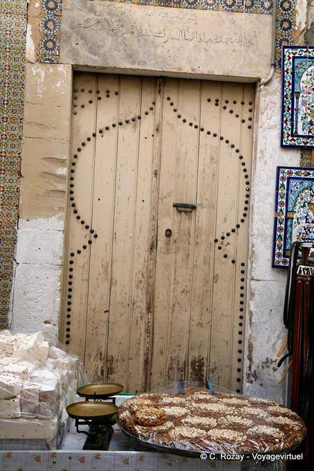 Vecchia porta di legno dietro una bancarella tratta, Sousse medina - Tunisia