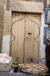 Vecchia porta di legno dietro una bancarella tratta, Sousse medina, Tunisia.