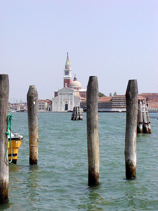 Colonne di legno nella laguna di fronte alla Basilica di San Giorgio Maggiore, Venezia, Italia
